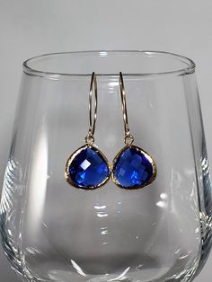 "September birthstone Sapphire earrings, a timeless classic perfect for any occasion. Beautiful Sapphire blue glass earrings feature faceted glass drops (15mm) framed in 16k gold dangling from petite almond-shaped ear wires hand forged in 14k Gold Fill with tumbled and polished ends for smoothness and comfort. Dainty earrings measure 1 3/4 inches from top to bottom and the faceted glass drop is 1/2 inch wide. Silicone backs included. In the September birthstone, these sapphire artisan earrings m Classic Teardrop Crystal Earrings For Parties, Classic Crystal Teardrop Earrings For Party, Classic Party Crystal Earrings With Ear Wire, Party Jewelry With French Hook Dangle, Teardrop Jewelry With Ear Wire For Parties, Nickel-free Sapphire Jewelry For Party, Sapphire Nickel-free Jewelry For Party, Classic Hypoallergenic Jewelry For Party, Teardrop Jewelry With French Hook For Party