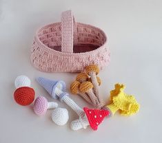 several crocheted objects are arranged on a white surface, including a basket with handles