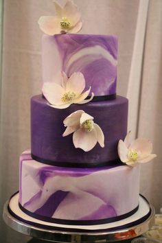 a purple and white cake with flowers on top