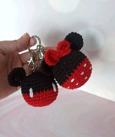 someone is holding two crocheted mickey mouse keychains in their left hand