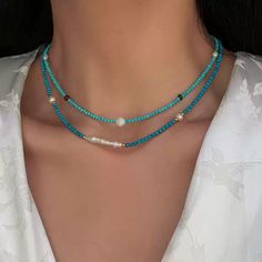 This delicate necklace brings together the serenity of turquoise beads with the subtle shimmer of moonstone. Each piece is meticulously crafted with natural freshwater pearls and blue turquoise accents, offering a unique combination of textures and colors. The adjustable chain ensures a comfortable fit, making this necklace perfect for layering or wearing on its own for a minimalist, chic look. Details Material: 24K gold-plated brass, natural freshwater pearls, turquoise, and moonstone Length: 46cm, 47cm, 46cm (with 5.5cm extension) Weight: Approx. 5.3g, 7.0g, 8.0g Style: Elegant and versatile, perfect for both casual and formal occasions Care Tips: Avoid exposure to harsh chemicals and keep dry to maintain its beauty Missy Jewelry Natural Stone Necklace Collection Turquoise Beaded Necklace, Natural Stone Necklace, Turquoise Accents, Turquoise Bead Necklaces, Necklace Collection, Pearl Jewelry Necklace, Natural Stones Necklace, Gold Statement Earrings, Minimalist Chic