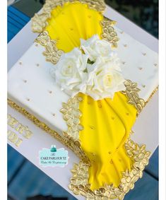 a yellow and white cake with flowers on top