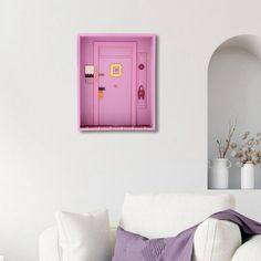 a living room with a white couch and pink door on the wall next to it