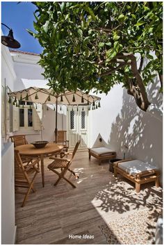 an outdoor patio with wooden furniture and umbrellas