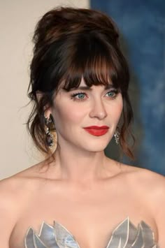 a close up of a person wearing a dress and earrings with red lipstick on her lips