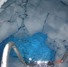 an escalator in the middle of ice with blue water coming out of it