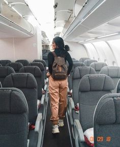 an instagram photo of a woman standing in the aisle of an airplane