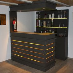 an empty bar with shelves and bottles on the wall in a room that has wood flooring