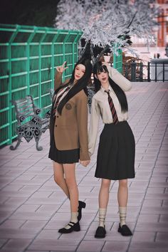 two young women standing next to each other on a sidewalk