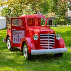 an old fashioned fire truck is parked in the grass