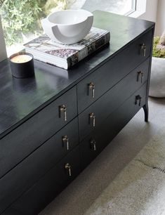 a white bowl sitting on top of a black dresser