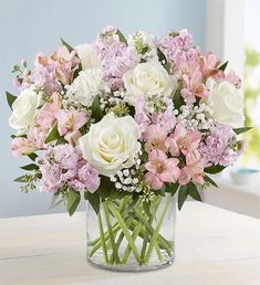 a vase filled with lots of white and pink flowers