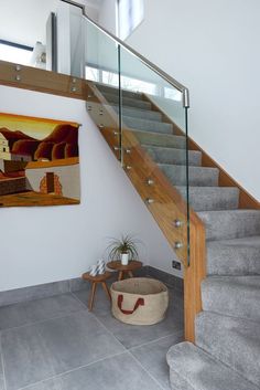 there is a painting on the wall next to some stairs and a basket in front of it