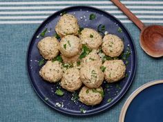 a blue plate topped with meatballs next to a wooden spoon