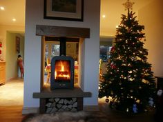 a living room with a christmas tree and fire place