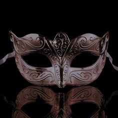 a masquerade mask on a reflective surface