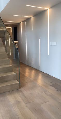 an empty room with some stairs and lights on the wall above it is lit up by leds