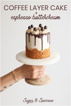 a person holding a cake on top of a white plate with the words coffee layer cake and espresso buttercream