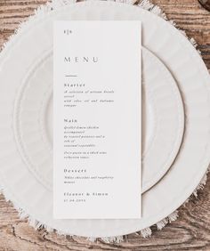 a white plate topped with a menu on top of a wooden table