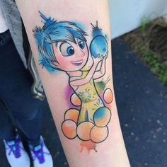 a person with a tattoo on their arm holding a blue ball and two orange balls