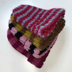 three knitted dishcloths stacked on top of each other in different colors and patterns