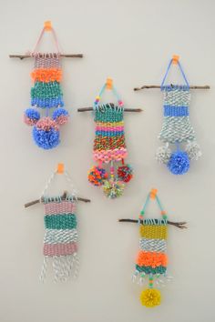 four different types of macrame hangings on a white wall, one with multicolored pom - poms