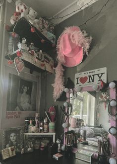 a room with pink and white decorations on the walls, shelves, and pictures hanging from the ceiling