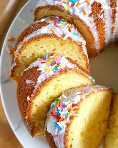 a cake with white frosting and colorful sprinkles on it sitting on a plate