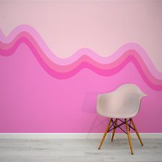 a white chair sitting in front of a wall with pink waves painted on it's side