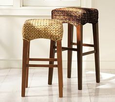 two stools sitting next to each other in front of a window with white tiles on the floor