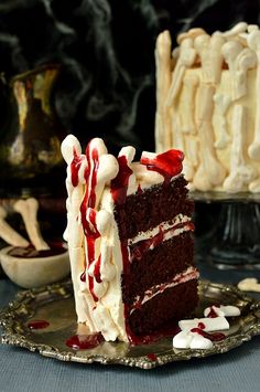 a slice of cake with white frosting and red toppings on a silver plate