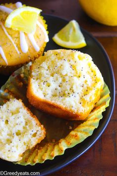 lemon poppy seed muffins on a black plate with lemons in the background