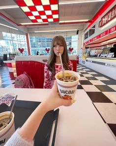 a woman sitting at a table with a bowl of food in front of her