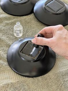 a hand is pressing the button on an appliance that's sitting on a bed