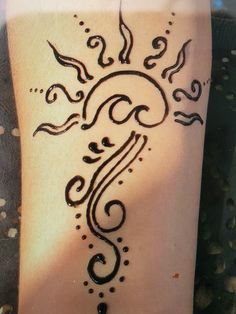 a woman's hand with a henna tattoo on the arm and foot,