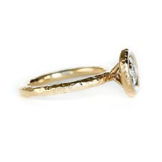 a yellow gold ring with a diamond in the center