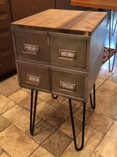 a metal and wood desk with three drawers on it's legs in a kitchen