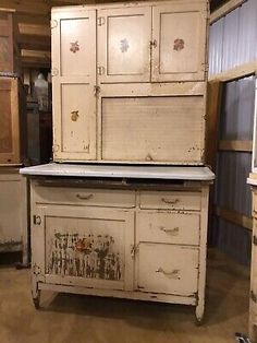 an old white cabinet sitting on top of a wooden floor