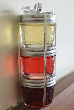 three jars stacked on top of each other with ribbons tied around the lids and sides