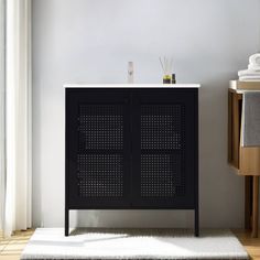 a bathroom with a white rug and black cabinet