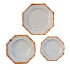 three white and gold plates with bamboo rims