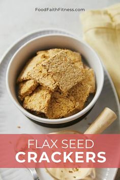 a bowl filled with flax seed crackers on top of a plate next to a spoon