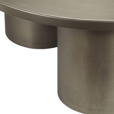 a round metal table with two legs on one side and an oval shaped base on the other