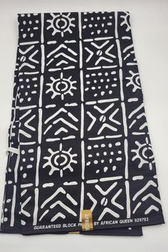 a black and white scarf with an abstract design on the front, featuring symbols in different sizes