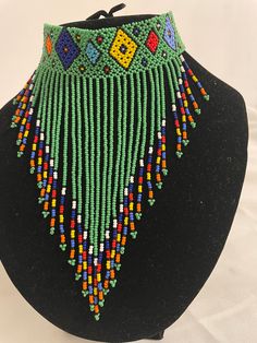 African, Zulu beaded choker. handmade green is the main colour. Turquoise Choker With Colorful Beads, Traditional Green Adjustable Necklace, Adjustable Green Artisan Jewelry, Green Adjustable Artisan Jewelry, Artisan Adjustable Green Jewelry, Artisan Green Jewelry For Festival, Green Handmade Traditional Necklaces, Handmade Round Beads Choker For Festivals, Handmade Green Bohemian Jewelry