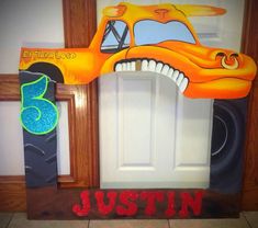 a door decorated with an orange car and the words, just in front of it