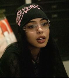 a young woman wearing glasses and a beanie