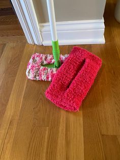 two mop heads laying on the floor next to a pair of crocheted mitts