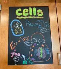 a blackboard with writing on it in front of a wooden door that says cells pro - no