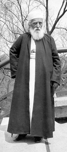 an old black and white photo of a man with a long beard wearing a robe